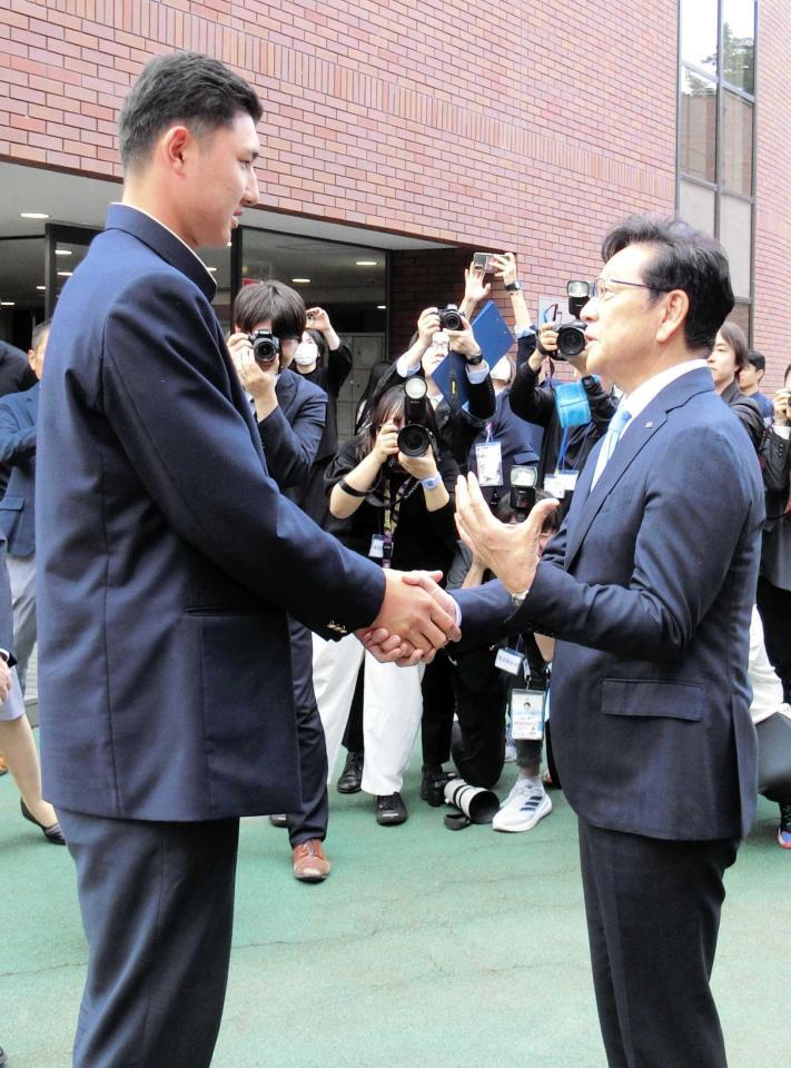 　菰田（左）と握手して言葉を交わす栗山ＣＢＯ