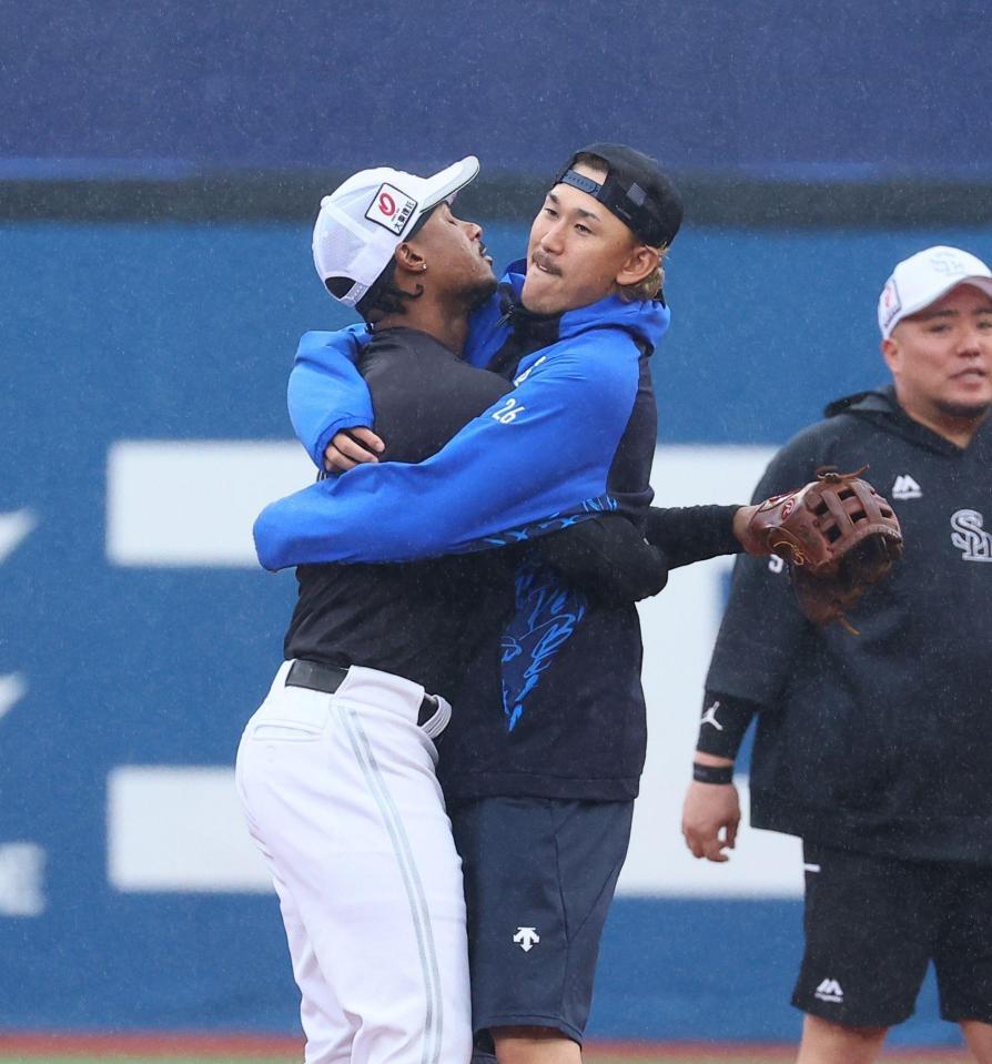 試合前、ダウンズ（左）とじゃれ合う三森（撮影・中島達哉）