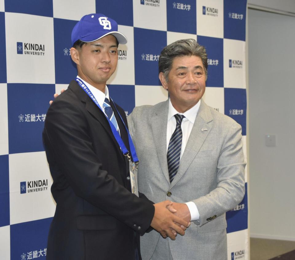 　指名あいさつに訪れた中日の工藤新監督（右）と握手する近大の宮原廉投手