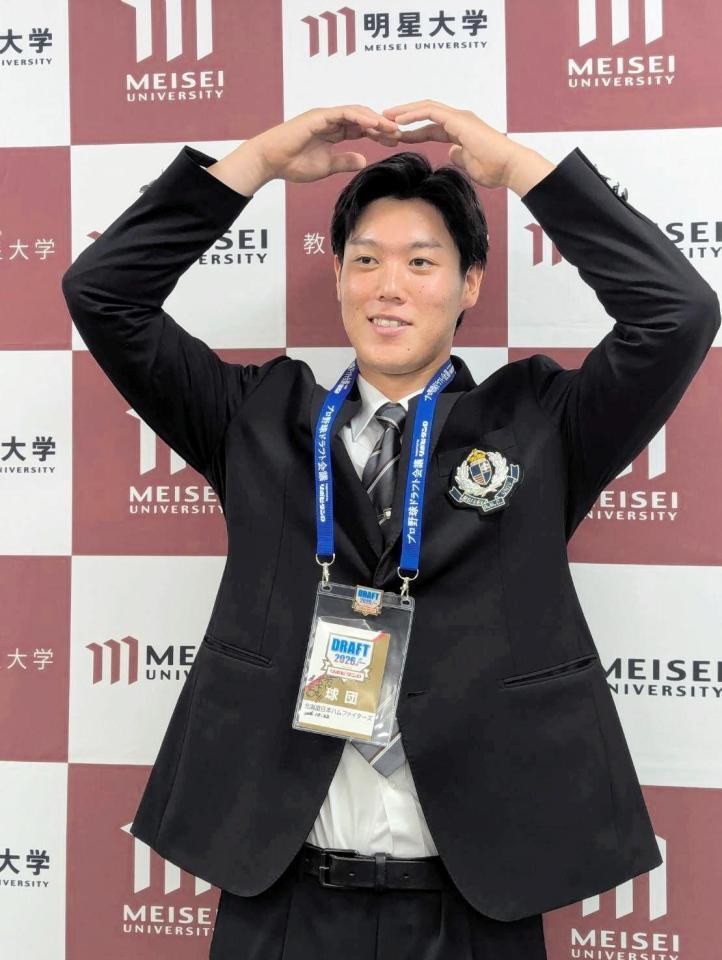 日本ハムからドラフト４位指名のあいさつを受けた明星大・加藤は、頭上でマル印のポーズをとる