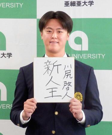 　目標を書いた色紙を手に笑顔で撮影に応じる、西武からドラフト１位で指名された亜大の川尻