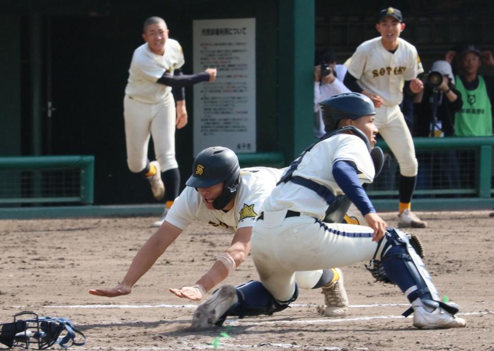 ９回、本塁へ滑り込み、一時同点とする崇徳・国川主将（撮影・市尻達拡）