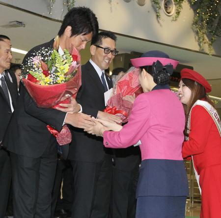 　前田健（左）とともに歓迎の花束を受け取り、笑顔を見せる野村監督（中）