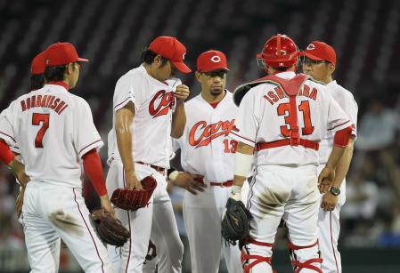 　８回、ピンチにマウンドで激励する野村監督（右端）の横で肩を落とす今村（中央）＝撮影・出月俊成　