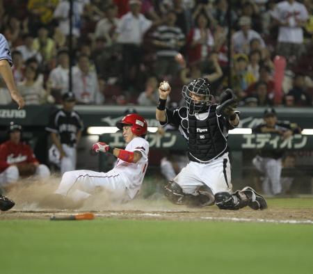 　９回、菊池の左前打で堂林がホームを狙うがタッチアウト。捕手藤井彰（撮影・出月俊成）