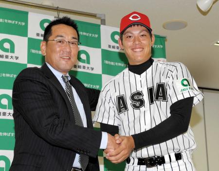 　指名あいさつを受け、野村監督（左）と握手する広島２位指名の亜大・九里