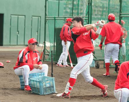 　高橋（右）が行うティー打撃を手伝う野村監督（撮影・市尻達拡）