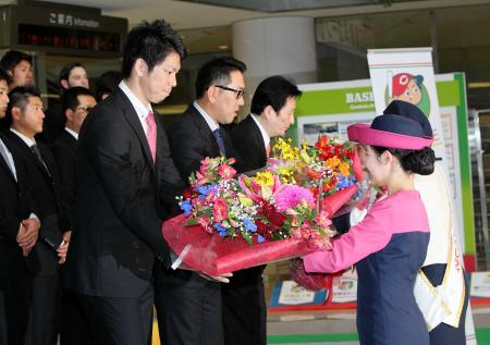 　宮崎入りし、セレモニーで花束を受け取る（左から）前田、野村監督（撮影・出月俊成）