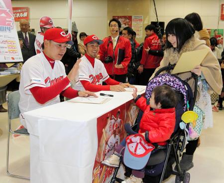 　サイン会で小さい子どもに手を振る（左から）丸と菊池