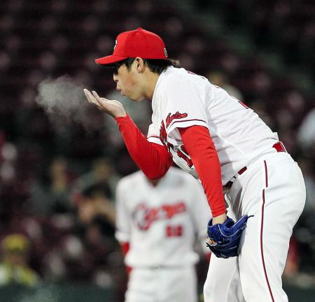 　手に付いたロジンを息で吹き飛ばす野村（撮影・出月俊成）　