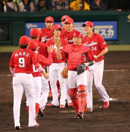 阪神をやぶり首位を守った大瀬良大地じゃナインハイタッチを交わす＝甲子園（撮影・持木克友）