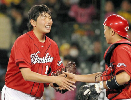 プロ初完投で３勝目を挙げ広島・石原慶幸（右）と握手を交わす広島・大瀬良大地＝甲子園（撮影・保田叔久）