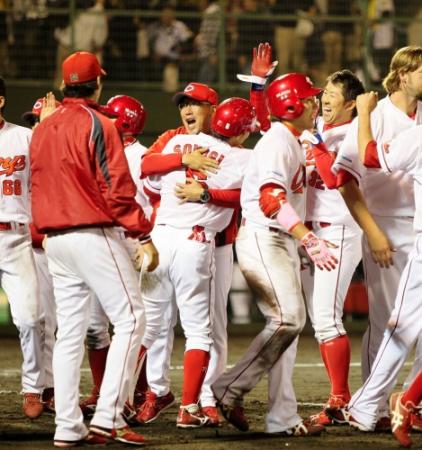 延長１２回、劇的なサヨナラ弾を放った広島・梵　英心と抱き合う広島・野村謙二郎監督（中央）＝どらドラパーク米子市民球場（撮影・出月俊成）