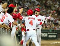 　８回、勝ち越しの犠飛を放った小窪と生還した丸（右）はベンチ前でタッチを交わす（撮影・出月俊成）