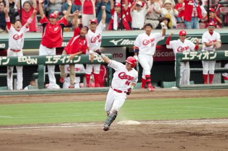 　８回、同点２ランを放ち、ガッツポーズで一塁を回る会沢（撮影・出月俊成）