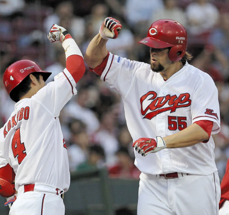 ３回、２ランを放ち、広島・小窪哲也とタッチを交わすＢ．エルドレッド（右）＝マツダスタジアム（撮影・出月俊成）