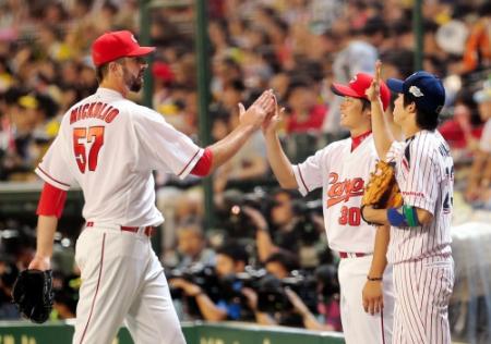 　９回を無失点に抑え、一岡らに迎えられるミコライオ（撮影・田中太一）