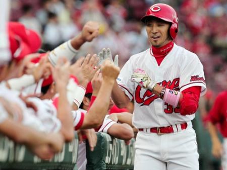 １回、先制ソロを放った広島・菊池涼介（右）はナインの出迎えに笑顔を見せる＝マツダスタジアム（撮影・出月俊成）