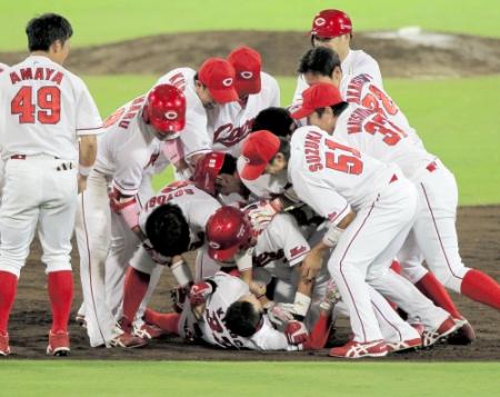 延長１０回、ヒーローの広菊池涼介（下）はナイン総出で押しつぶされる（撮影・出月俊成）