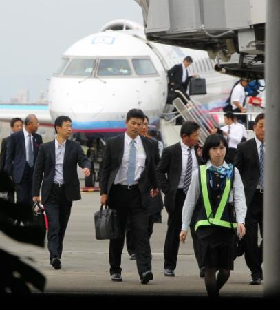 秋季キャンプへ向け、宮崎空港に降り立った緒方監督（中央）＝撮影・出月俊成