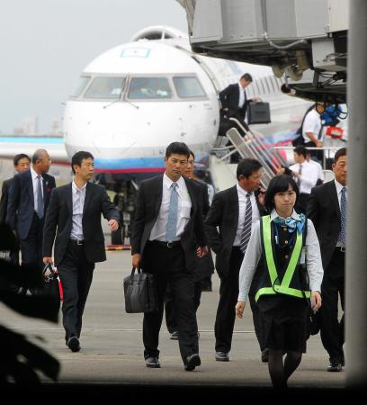 　秋季キャンプへ向け、宮崎空港に降り立った緒方監督（中央）（撮影・出月俊成）