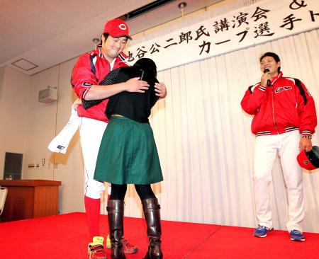 　カープ女子にハグのプレゼントをする中崎（左）。右は九里