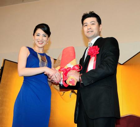 ミス・インターナショナル２０１２のグランプリを獲得した吉松育美（左）から祝福の花束を贈られ笑顔を見せる緒方監督（撮影・出月俊成）