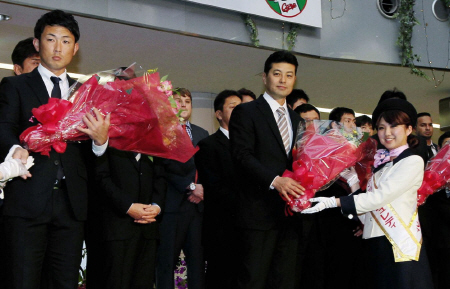 宮崎入りし空港で歓迎の花束を受け取る緒方監督（中央右）、梵選手会長（同左）＝撮影・出月俊成