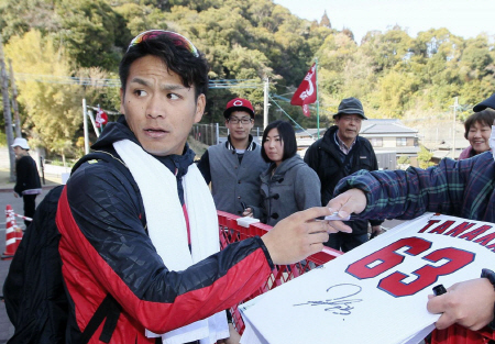 休日返上のトレーニングを終え、ファンにサインする広島・田中広輔（左）＝日南（撮影・出月俊成）