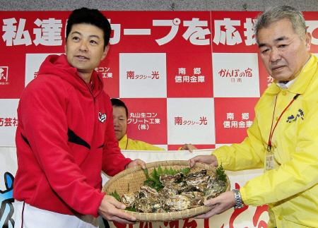 練習前に広島かきを贈られた広島・緒方孝市監督（左）＝日南（撮影・出月俊成）