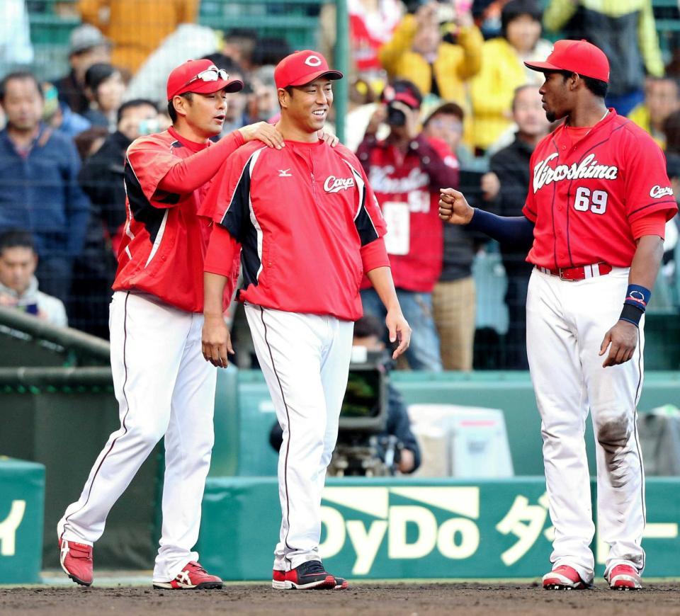 　今季２勝目を挙げ緒方監督（左）に肩をもまれる黒田。右は４安打と大活躍したロサリオ（撮影・持木克友）