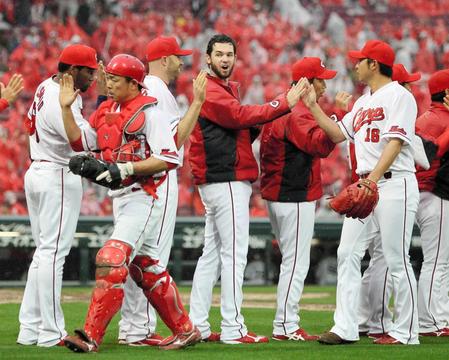 　今季２勝目を挙げ、ナインを迎えるジョンソン（中央）＝撮影・出月俊成