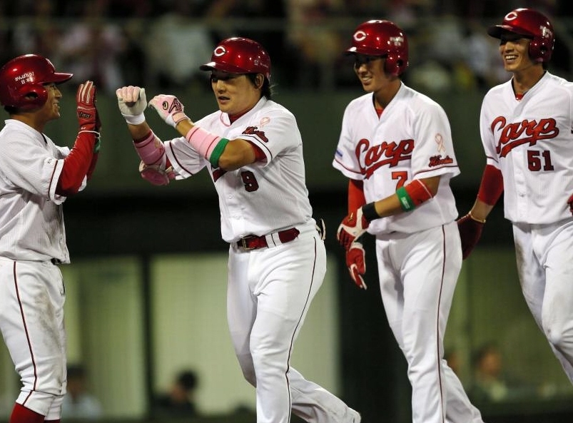 ８回、満塁弾を放ち、ナインに迎えられる広島・丸佳浩（中央）＝尾道（撮影・出月俊成）