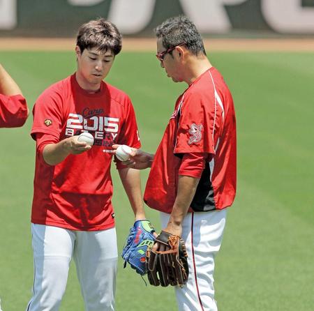 　野村（左）にカーブの投げ方を教わる黒田（撮影・北村雅宏）