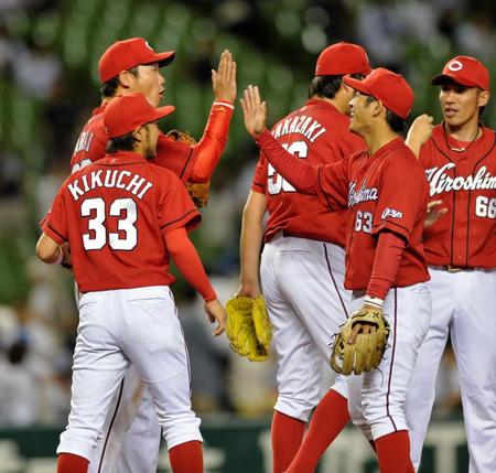 西武に逆転勝ちし、新井貴浩（左）と笑顔でタッチする広島・田中広輔（右から２人目）＝西武プリンスドーム（撮影・西岡正）