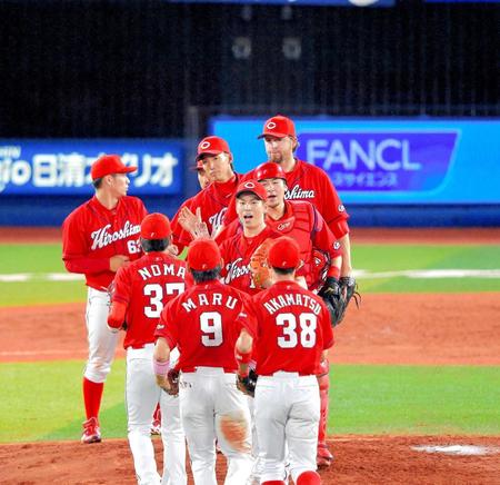 　球団通算４０００勝を完投で飾り、ナインとタッチをかわす前田（中央）＝撮影・堀内翔