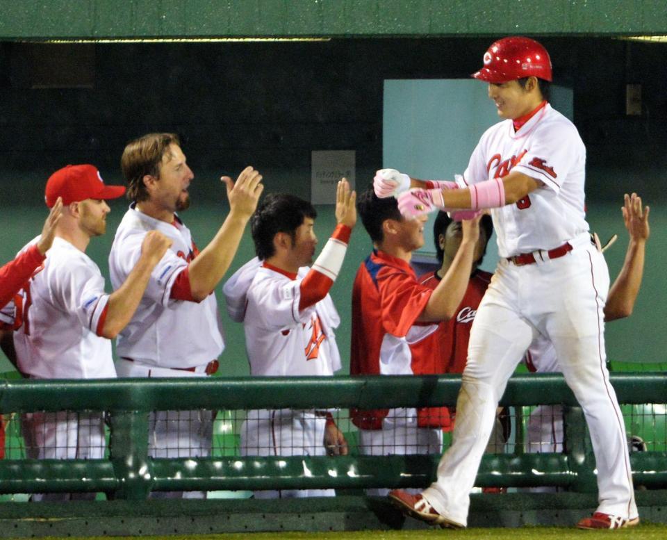 ４回広島１死二塁、丸佳浩（左）は右越えに勝ち越し２ランを放ち、ナインに祝福される＝長野オリンピックスタジアム（撮影・西岡正）