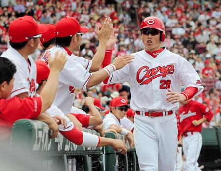 １回、広島・会沢翼の適時打で生還し、ナインに迎えられる広島・新井貴浩（右）＝マツダスタジアム（撮影・出月俊成）