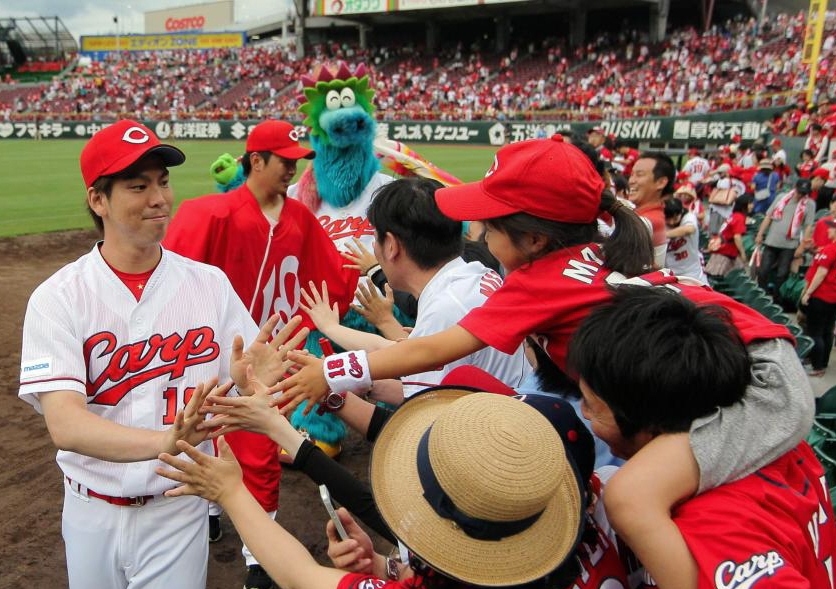 今季６勝目を挙げ、小さな“カープ女子”の祝福に笑顔を見せる広島・前田健太（左・後ろは広島・大瀬良大地）＝マツダスタジアム（撮影・出月俊成）