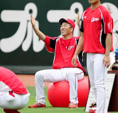 　練習前にトレーニングボールに座り笑顔を見せる黒田