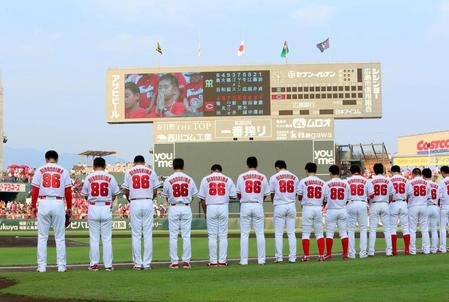 半旗が掲げられる下で「８６」のユニホームを着て黙とうするカープナイン