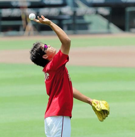 　空に向かってボールを投げる九里