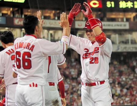 ８回、本塁打を放ち、ナインの出迎えに笑顔を見せる新井（右）＝マツダスタジアム（撮影・出月俊成）