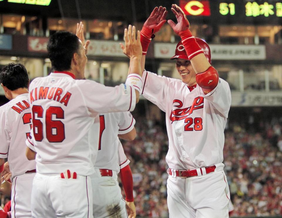 ８回、本塁打を放ち、ナインの出迎えに笑顔を見せる新井（右）＝マツダスタジアム（撮影・出月俊成）