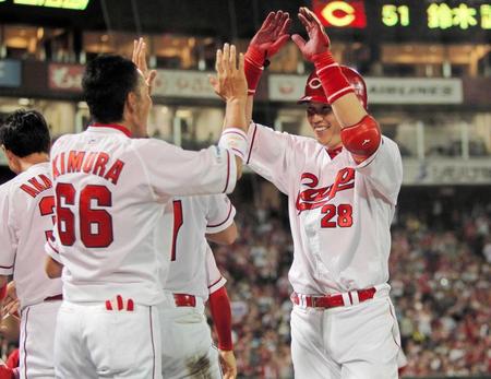 　８回、ソロを放ち、ナインの出迎えに笑顔を見せる新井（右）＝撮影・出月俊成