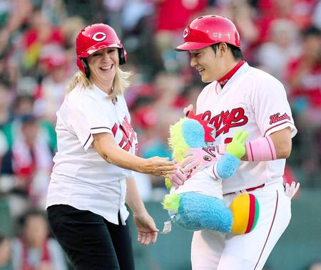 　１回、先頭打者弾を放ち、エルドレッドの母・シンディさん（左）からスラィリー人形を受け取る丸（撮影・出月俊成）