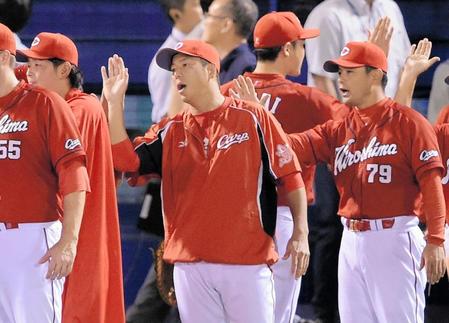 ヤクルトに競り勝ち、ナインとタッチを交わす黒田（中央）と緒方監督（右）＝撮影・吉澤敬太