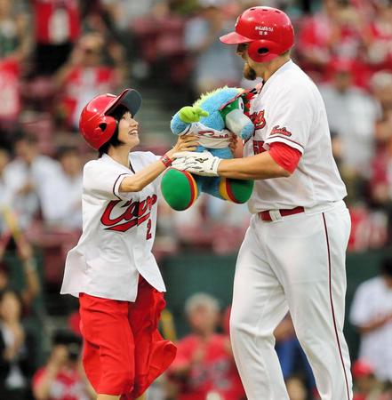 １回、先制２ランを放った広島　ブラッド・エルドレッド（右）にスラィリー人形を手渡す１日ホームランガールの藤木淳子さん＝マツダスタジアム（撮影・出月俊成）