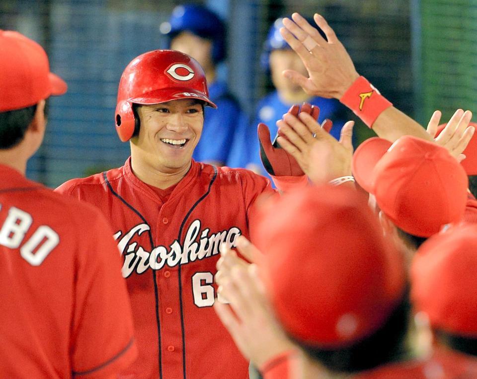 　５回、右越えソロを放ち、笑顔でナインに迎えられる田中（撮影・吉澤敬太）