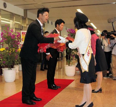 キャンプ地入りし、歓迎の花束を受け取る（左から）広島・緒方孝市監督と広島・小窪哲也＝宮崎空港（撮影・出月俊成）